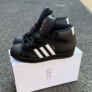 Adidas Black and White High-Tops with Gold Accents